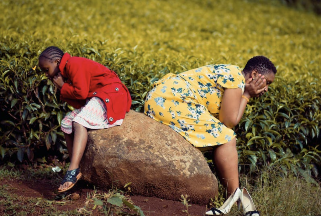 two girls sitting on a rock
